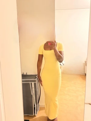 Sundress/ långklänning  - Snygg gul långklänning med tight passform och korta ärmar. Klänningen har en fyrkantig urringning och är gjord i ett stretchigt material som sitter skönt mot kroppen. Perfekt för dig som vill sticka ut med färg och stil.