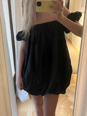 Svart offshoulder ballongklänning  - Säljer denna svarta kortklänning med offshoulder-design och puffiga ärmar. Klänningen har en lös och luftig passform med ballongliknande form nedtill. ❤️helt oanvänd