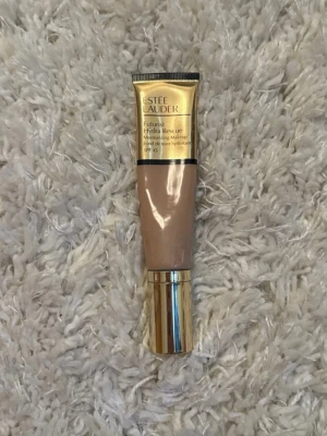Estée Lauder Futurist Hydra Rescue Foundation - Foundation från Estée Lauder i nyansen 3C2 Pebble. Tuben är guldig och beige med guldfärgat lock. Produkten är en återfuktande foundation med SPF 45 och har en krämig konsistens som ger naturlig täckning.