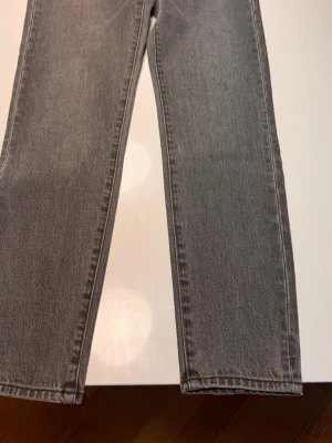 Grå raka jeans från Neuw storlek 26/30 - Snygga grå jeans från Neuw med rak passform och klassisk femficksdesign. Jeansen är tillverkade i denim och har en stilren look som passar perfekt till en avslappnad outfit. Märkeslapp bak och diskreta sömmar för en clean vibe.