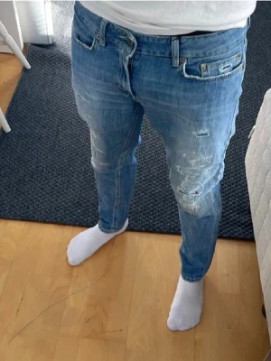 Dondup jeans med slitningar  - Säljer nu mina rikitgt snygga jeans från dondup med riktigt sköna slitningar. OBS inga hål bara slitningar som är menade att vara där! De har en klassisk femficksdesign och en knappgylf. Nypris ca 3500kr. 🌟Tyvär har lappen med storlek åkt av (sista bilden) men skulle säga att dem sitter som mellan w 28- w30. SKRIV VID FUNDERINGAR😁