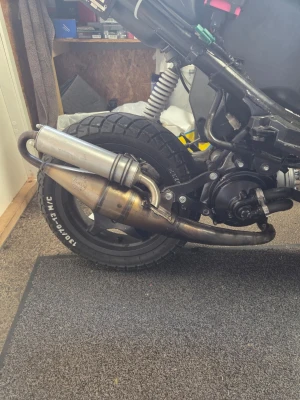 Tt till roxx - Säljer ett avgassystem till moped i metall med sportigt utseende. Systemet har en silverfärgad ljuddämpare och böjt rör i rostfritt stål. Passar dig som vill uppgradera ljudet och prestandan på din moppe.