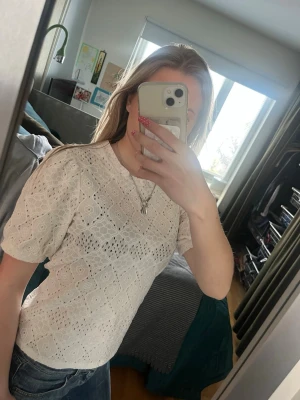 Vit spetsblus med kort ärm från object  - Superfin vit blus i spets med korta ärmar och rund hals. Blusen har ett broderat mönster och är lätt genomskinlig, storlek xs från object. Orglinalpris ca 499kr