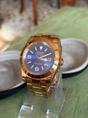 Seiko Explorer Roseguld - Stilren Seiko Explorer klocka i roseguld färg. Urtavlan är blå med vita index och siffror samt. Automatisk rörelse och robust design, perfekt för dig som gillar klassisk men modern stil.