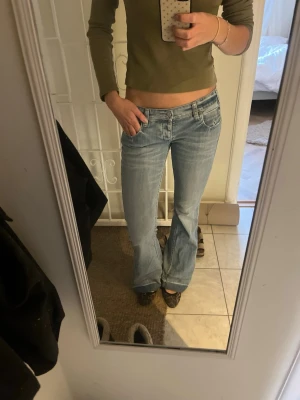 Ljusblå bootcut jeans från Pinko  - Säljer ett par ljusblå bootcut jeans från pinko med snygga broderade detaljer på bakfickorna och slitningar vid benslut. Jeansen är uppsprättade längst ner💕