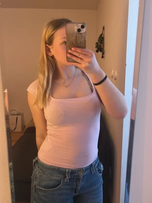 Ljusrosa tight topp från Gina Tricot - Säljer en ljusrosa topp med tight passform och korta ärmar.