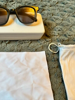 Svarta solglasögon från chimi  - Snygga svarta solglasögon från chimi med klassisk, fyrkantig båge och mörka glas. Kommer med vit hård förvaringsbox och tygpåse. Perfekta för att lyfta din stil under soliga dagar.