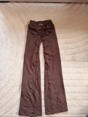 Bruna utsvängda leggings från dfyne  - Säljer ett par bruna leggings från dfyme med utsvängda ben och medel hög midja. Tillverkade i ett stretchigt material som sitter skönt och följer kroppen. Perfekta för dig som gillar en trendig och bekväm look.