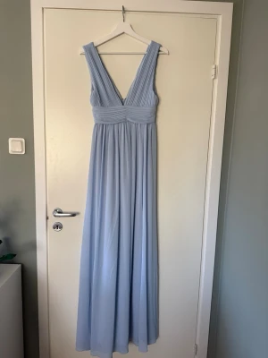 Ljusblå balklänning - Elegant ljusblå balklänning med breda band och  v-ringning både fram och bak. Köpte den second hand men säljer då den inte passade ☺️