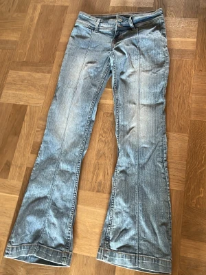 Ljusblå bootcut jeans med pressveck - Säljer ett par ljusblå bootcut jeans med markerade pressveck framtill. Jeansen har klassisk femficksdesign och utsvängda ben. Perfekta för dig som gillar retrostil och vill ha ett par jeans som sticker ut lite extra. Det står ingen storlek på de men de är lite för stora för mig som har storlek xs/s men det är väldigt stretchigt och bekvämt tyg💕
