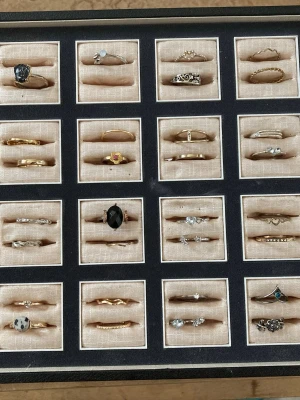 Mix av stilrena och unika ringar - Säljer ett set med flera olika ringar i guld- och silvertoner, vissa med stenar, pärlor och detaljerade mönster. Ringarna har olika former, från klassiska till mer kreativa designer, och passar dig som gillar att variera din stil med accessoarer. Priser varierar, fråga gärna. En st u 40-100 kr. Fem st 250- 400, 10 st 500- 750 kr och alla för 2000 kr. 