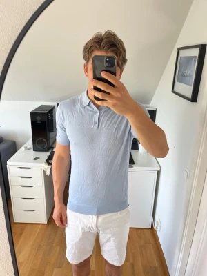 Ljusblå pikétröja från Replay - Snygg ljusblå pikétröja från Replay med klassisk krage och knappar framtill. Tröjan har korta ärmar och är tillverkad i ett mjukt material som känns skönt mot huden. Följer med en extra knapp. Hör gärna av dig vid frågor!