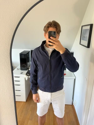 Mörkblå vindjacka från Espirit - Snygg mörkblå vindjacka med dragkedja och ståkrage. Jackan har två fickor med tryckknappar och ribbade muddar vid ärmslut och midja. Hör gärna av dig vid frågor!