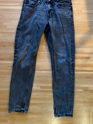 Svarta raka jeans från Cubus - Säljer ett par svarta raka jeans från Cubus med klassisk femficksmodell och knappgylf. Jeansen har en tvättad look och är tillverkade i bomull med lite stretch för extra komfort. Perfekta till en avslappnad streetstil.
