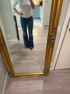 Blå bootcut jeans med låg midja -  Storlek 27/34 avklippta där nere så dom ska passa mig som är 169. Mått:36 midja och 79 innerben