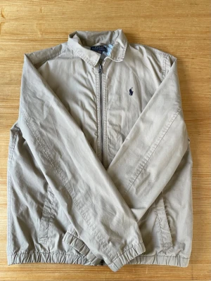 Beige vindjacka från Polo Ralph Lauren - Säljer en beige vindjacka från Polo Ralph Lauren i storlek S. Skick 8/10. Nypris 2400 men säljer för 600. Passar perfekt till 176 till ish 179. Kan tvättas och strykas innan jag skickar.