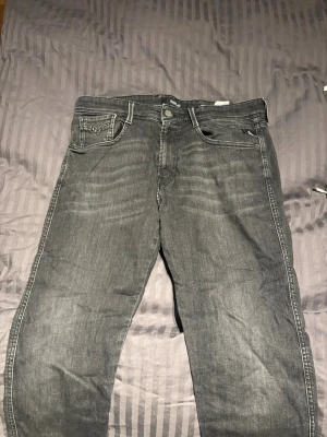 Grå jeans från Replay 33/34 - Säljer ett par gråa jeans från Replay. Jeansen har snygga slitningar framtill och tydliga sömmar på bakfickorna. Materialet är i mjukt denim:) 33/34 
