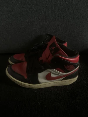 Air Jordan 1 Retro röd svart vit - Snygga Air Jordan 1 Retro sneakers i klassisk färgkombination av rött, svart och vitt. Rätt gamla därav det bra priset!