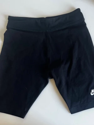 Svarta tighta träningsshorts Nike - Svarta tighta träningsshorts från Nike med klassisk logga på benet. I bra skick storlek 158-164. Tveka inte att skriva vid frågor och kolla gärna in mina andra annonser!💕