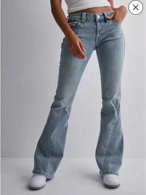 Blå bootcut jeans sop True Religion - Säljer ett par ljusblå bootcut jeans från True Religion pga att dom är för stora och kommer inte till användning. Använda ungefär 3 gånger. Storlek 27