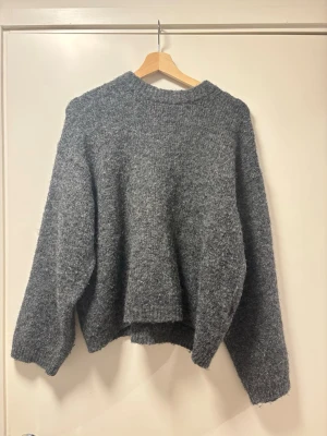 Grå oversized stickad tröja - Mysig grå stickad tröja med oversized passform och rund hals från Gina. Välanvänd men bra kvalitet fortfarande.
