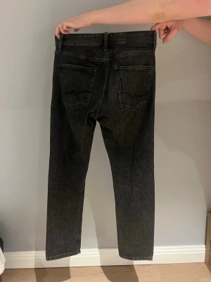  Jack and Jones - Mörkgråa/svarta raka jeans från Jack and Jones i storlek w29 L 32