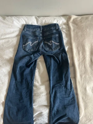 Nelly low waist bootcut stitch jeans - Supersnygga trendiga jeans från Nelly i storlek S. Använda väldigt väldigt lite (pga av kommer inte till användning) så har absolut inga defekter eller liknande. Nypris 700kr. Bara att skriva om frågor!🥰