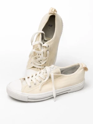 Beige canvas sneakers från H&M - Stilrena beige sneakers från H&M i canvasmaterial med vita gummisulor och tåhätta. Klassisk låg modell med vita skosnören och metallöljetter. Perfekta för en avslappnad och trendig look.