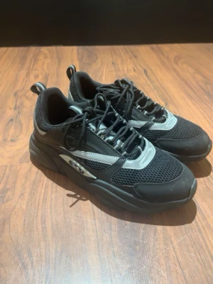 Dior B22 - Säljer dessa riktigt fräscha Dior B22 då de inte min stil längre. Skorna är i 10/10 skick och har inga skador eller så. De grå/silver detaljerna på skorna är reflekterade, alltså de lyser när man tar bild med blixt eller när de får ljus på sig när man är ute. Om du har frågor eller är intresserad så är det bara att höra av dig🤝