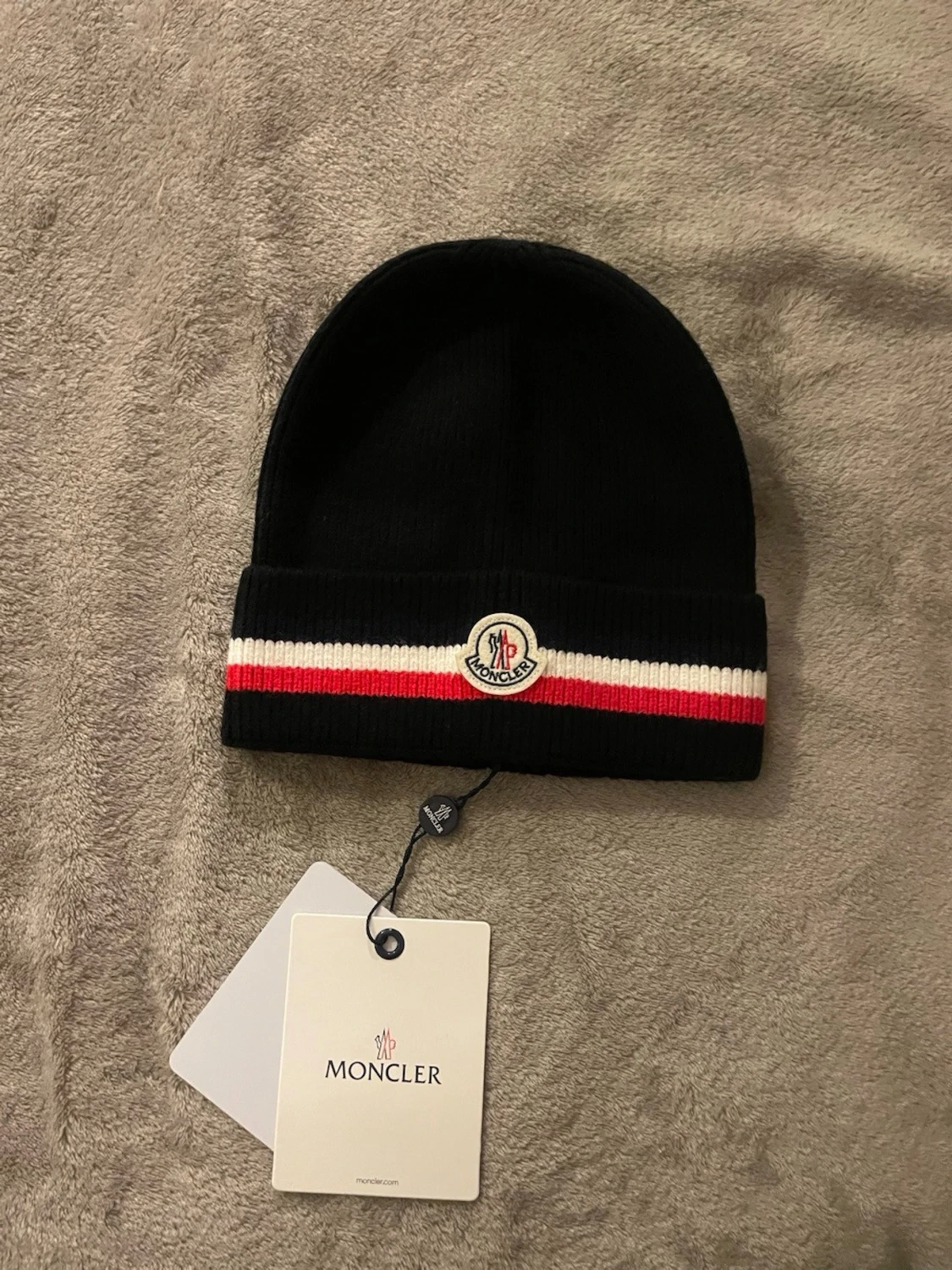 Svart Moncler mössa med röd/vit rand