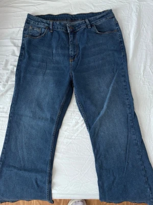 Blå bootcut jeans med fem fickor - Säljer ett par klassiska blå bootcut jeans med fem fickor och bälteshällor. Jeansen har en hög midja och breda ben.  Passar nog någon i stl: 50/52 skulle jag tro. Fick dessa o de var alldeles för stora men fina ankel jeans med mycket stretch.