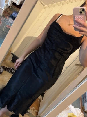 Svart långklänning med smala axelband - Stilren svart långklänning med smala axelband och lätt draperad urringning. Behöver bara strykas 