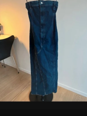 Mörkblå lång jeanskjol - Säljer en mörkblå lång jeanskjol med hög midja och rå kant nertill. Klänningen är från pull&bear storlek S 