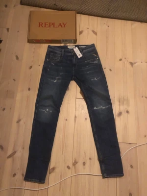 Replay anbass slitningar  - Säljer ett par mörkblå jeans från Replay med slitningar och slim fit. Klassisk femficksmodell med snygga detaljer och stretchigt denimtyg för extra komfort cheeky look. Perfekta för dig som vill ha en trendig och avslappnad stil. Jag är väldigt osäker på va dom är värda eftersom dom är helt nya och väldigt efterfrågade så man kan också buda på mindre. Skriv vid frågor!