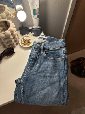 Gina tricot jeans - Säljer ett par klassiska blåa jeans från Gina tricot Perfect Jeans. De har fem fickor, bootcut och snygga kontrastsömmar. Perfekta till vardagslooken och passar till det mesta🤍