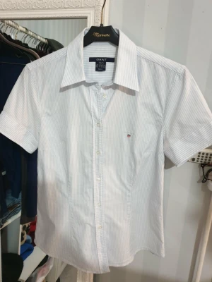 Kortärmad skjorta  - Ljusblå och vit randig kortärmad skjorta från Gant i jättefint skick.