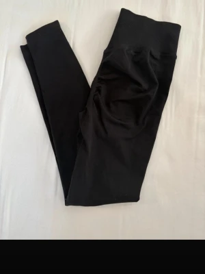 Svarta scrunch-leggings med hög midja - Säljer ett par svarta leggings med scrunch-detalj bak och bred, ribbad hög midja. De är stretchiga och sitter tight, perfekta till träning eller chill. Materialet känns mjukt och följsamt. De är från shein. Och har ett litet hål vid innerlåret som absolut inte märks men därav ett lägre pris. 