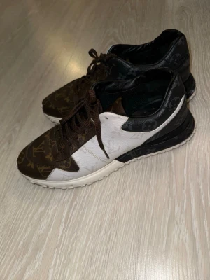Louis Vuitton monogram sneakers - Snygga sneakers från Louis Vuitton med klassiskt monogrammönster i brunt, vitt och svart. Skorna har låga skaft, bruna skosnören och en vit sula. Använda några gånger men är i bra skick