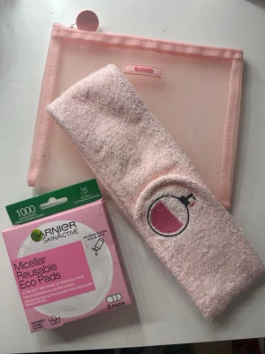 Rosa sminkväska och pannband - Säljer ett set med en rosa mesh-sminkväska från Glowid, ett mjukt rosa frottépannband med broderad parfymflaska samt Garnier SkinActive Micellar Reusable Eco Pads (3-pack) i originalförpackning. Perfekt för din hudvårdsrutin och sminkborttagning.