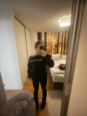 Svart hoodie från Vision Violet - Säljer en mörkblå hoddie från Gina med vit text på bröstet. Hoodien har en avslappnad passform och långa ärmar. Perfekt för en chill och stilren look.