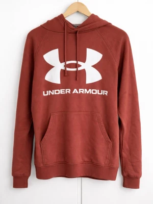 Rostbrun hoodie från Under Armour - Snygg rostbrun hoodie från Under Armour med stor vit logga och text på bröstet. Klassisk känguruficka framtill och justerbar dragsko i huvan. Perfekt för en sportig och avslappnad stil.