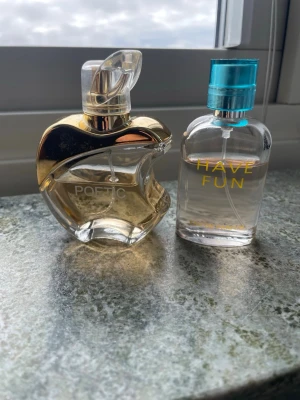 Två parfymer Poetic & Have Fun - Säljer två parfymer: Poetic i en unik, äppelformad flaska med guld- och transparent design samt Have Fun i en rund, transparent flaska med blått lock och gul text. Båda flaskorna är snygga och perfekta att ha framme på hyllan. Halva volymen kvar på poetic och en två tredje del kvar på Have Fun
