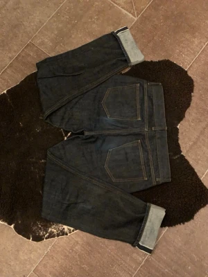 Arket selvedge denim - Säljer ett par mörkblå Arket selvedge denim jeans med raka ben och klassiska fem fickor. Tillverkade i kraftig denim som ger en tidlös look. W31 L32. Hör gärna av er vid frågor! Priset är intr hugget i sten!
