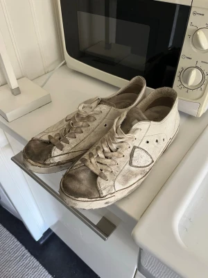Vita Phillipe model skor - Vita sneakers med lågt skaft och klassisk snörning. Skorna har en enkel design med rund sop och detaljer .Passar perfekt till en lesquels avslappnad stil. Lite smutsiga men enkelt att putsa till.