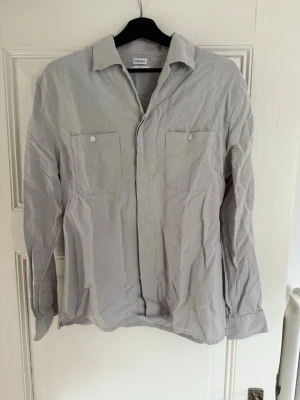 Ljusgrå skjorta från Filippa K - Skjorta från Filippa K i tjockt linne material. Sjukt snygg och sparsamt använd. Säljer den då den är för liten för mig. 