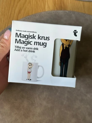 Magisk mugg med rolig motiv - Säljer en magisk mugg som ändrar motiv när du häller i varm dryck. Motivet visar en tecknad person som byter från kläder till underkläder. Muggen är vit med tryck och kommer i originalförpackning. Perfekt present till någon med humor.