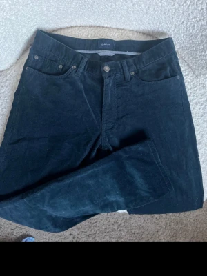 Gant Slim Chinos – Strl 30/32 – fint skick - Säljer ett par klassiska och stilrena chinos från Gant i passformen "Slim". En perfekt basbyxa som passar till det mesta.  Storlek: Midja 30 / Längd 32  Modell: Slim  Material: Skön bomullskvalitet med lätt stretch  Skick: Mycket fint och välvårdat skick.  Detaljer: Gylf med dragkedja och knapp, samt diskret Gant-logga ovanför bakfickan. Passar perfekt till både skjorta, piké eller en vanlig t-shirt.