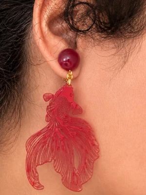 Röda statement örhängen med fiskmotiv - Unika röda örhängen med fisk . Guldfärgade metalldelar och clip-on fäste. Perfekta för dig som vill sticka ut med ett kreativt och lekfullt smycke.
