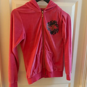 Rosa kofta Juicy Couture  - Juicy couture kofta köpt för länge sedan. Använd esdast inomhus 3-4 gånger. Den säljs inte längre och är i bra skick. Strl M men är lite tajt så skulle säga S-M. Den köptes för 700kr.