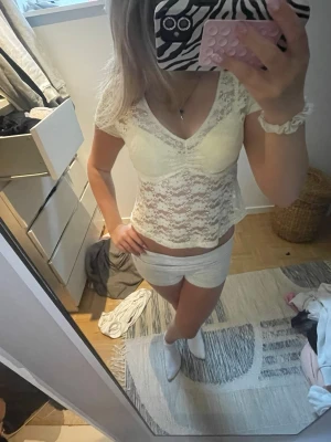 ljusgul spetsblus med v-ringning - Söt ljusgul blus i spets med v-ringad hals och korta ärmar. Transparent spetsmaterial ger en romantisk känsla och toppen är figurnära. Perfekt att styla med jeans eller kjol för en trendig look.
